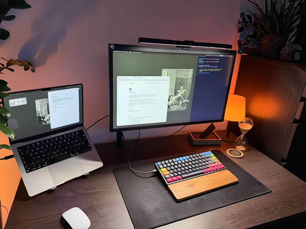 A brown desk on which a MacBook Pro, an LG Ultrafine display and a Keychron mechinal keyboard is placed.